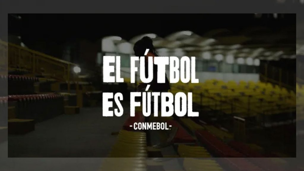 Silueta de una jugadora de fútbol en la tribuna de un estadio con el sobreimpreso "Fútbol es fútbol, Conmebol" en letras blancas.