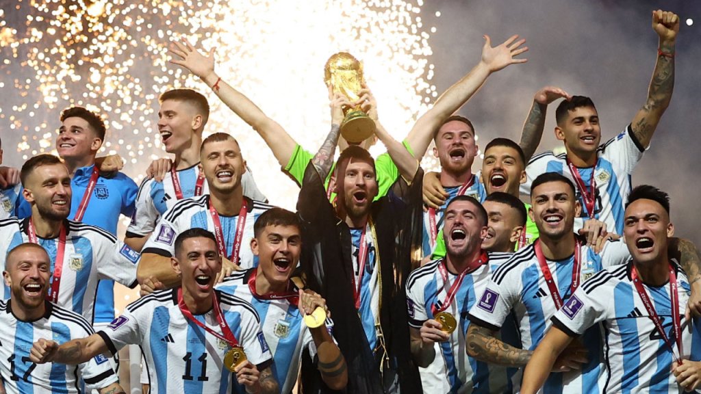 Foto de los jugadores de la selección de fútbol masculino de Argentina. En el medio Lionel Messi levantando la copa y a su alrededor algunos de los jugadores.
