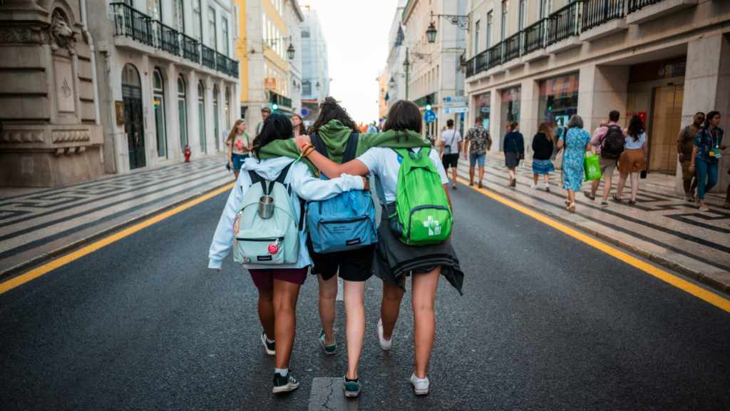 Tres adolescentes caminando por la calle mientras se abrazan.